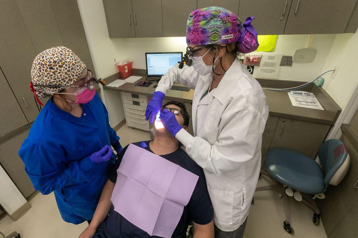Two San Juan College dental students work on a patient