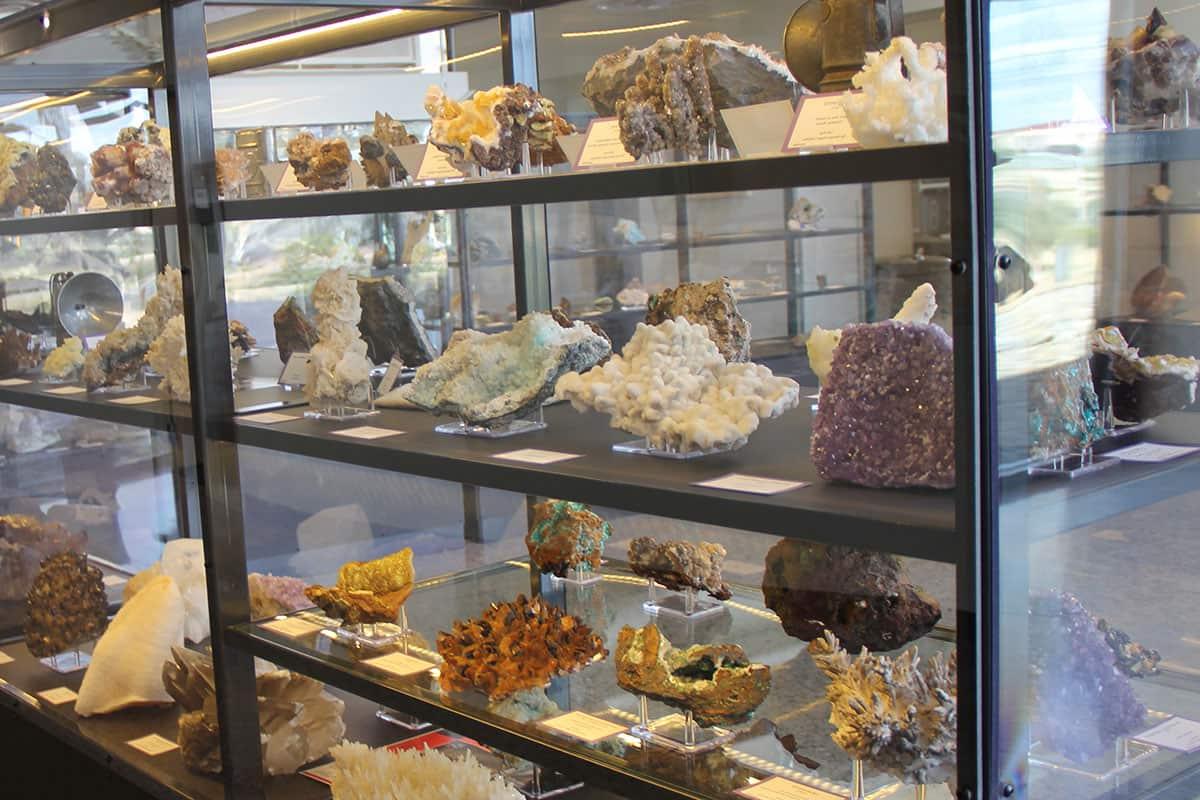 A glass display case with shelves of geodes and crystals