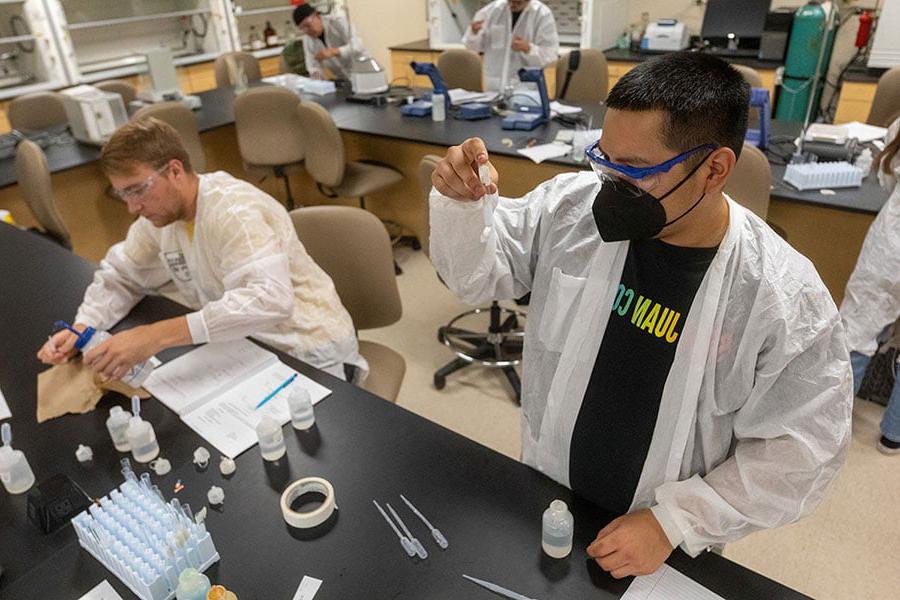 Two San Juan College students preparing samples in the chemistry lab